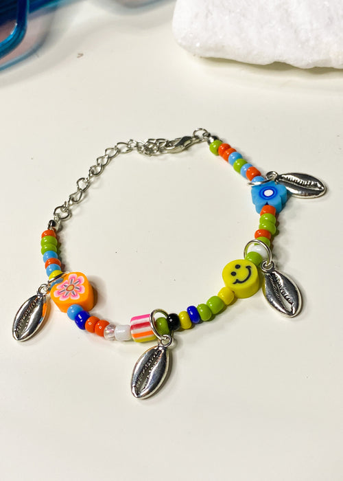 Pulsera con dijes de conchas y cuentas de colores