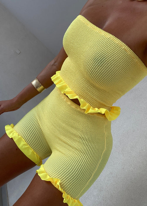 Conjunto de minipantalones cortos y bandeau con peplum en amarillo