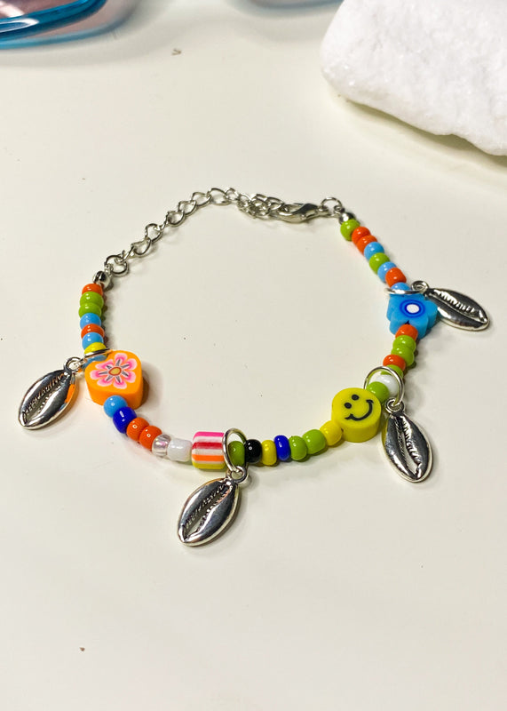 Pulsera con dijes de conchas y cuentas de colores