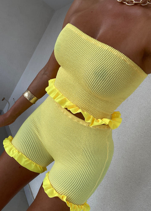 Conjunto de minipantalones cortos y bandeau con peplum en amarillo