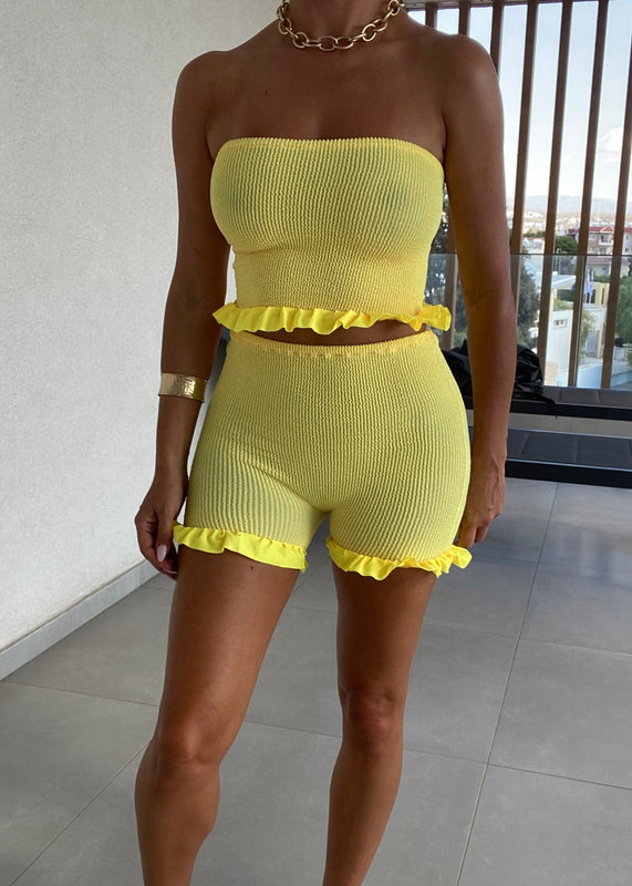 Conjunto de minipantalones cortos y bandeau con peplum en amarillo